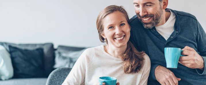 man and woman sitting down with mugs