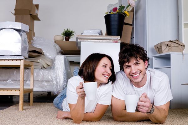 man and woman lying on floor with mugs smiling