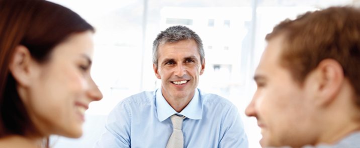 over shoulder man and woman smiling at eachother other man in middle