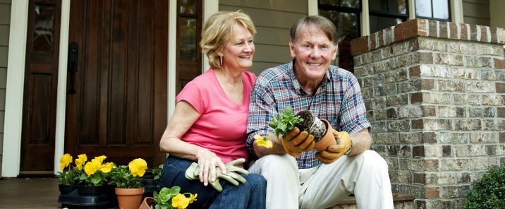 elderly couple potting plants gardening