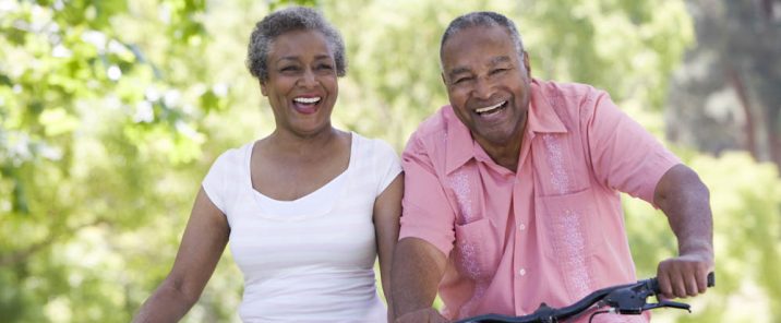 elderly couple riding bikes outside