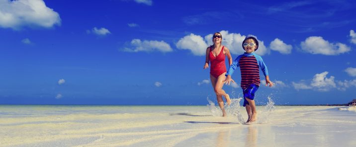 mother and son running on water at beach