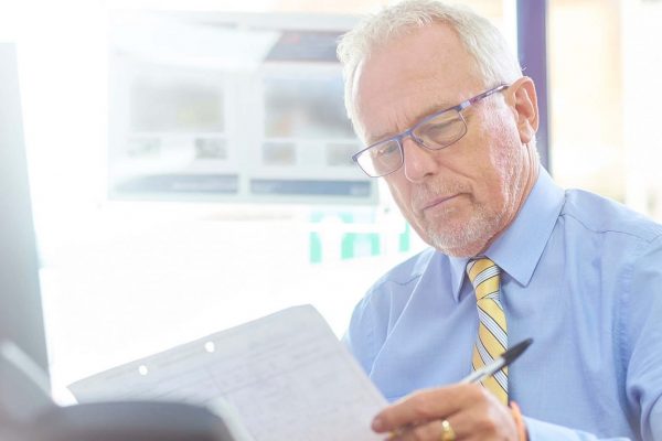 man in office at desk looking at paper