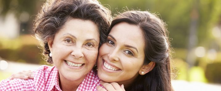 Elderly mother and daughter outside smiling