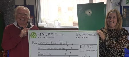 sherwood forest food bank man and woman holding mansfield cheque