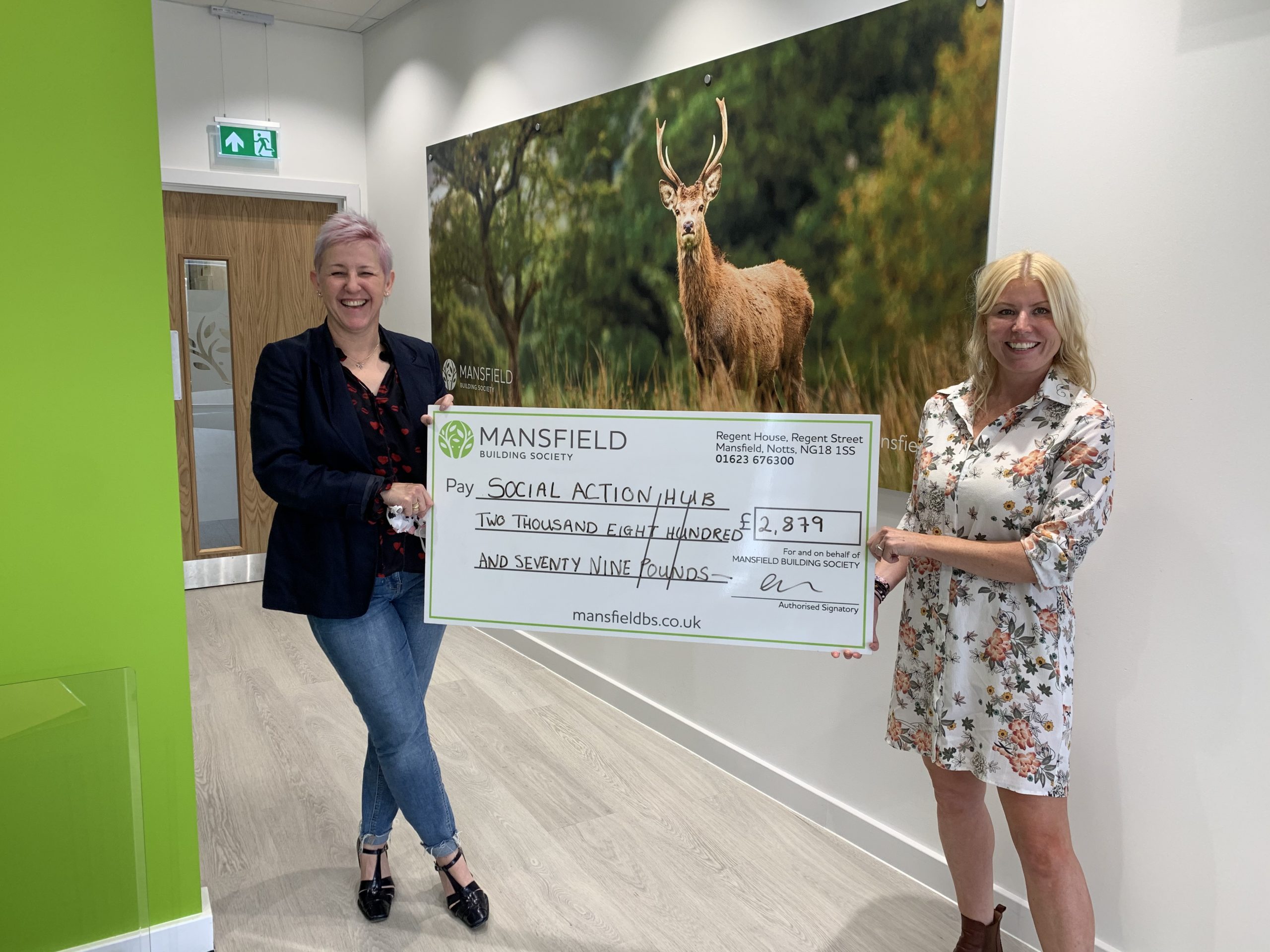 two women holding mansfield cheque deer painting background