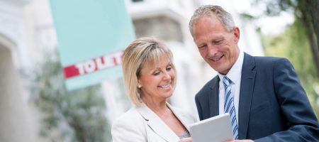Man and woman looking pointing at tablet