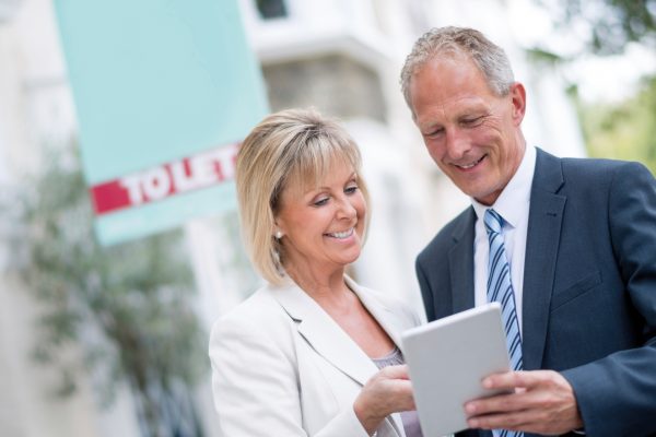 Man and woman looking pointing at tablet