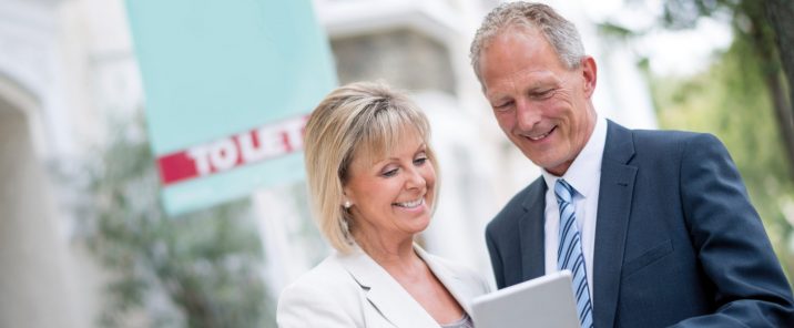 Man and woman looking pointing at tablet