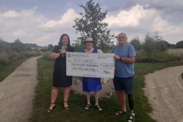 Man and two women HELP group large mansfield bs cheque