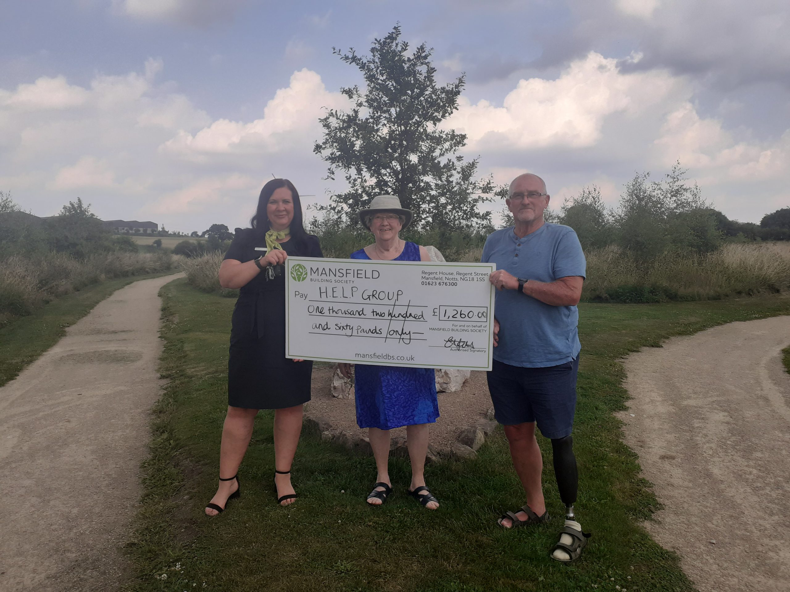 Man and two women HELP group large mansfield bs cheque