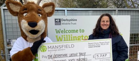 Woman and deer mascot holding cheque derbyshire wildlife trust