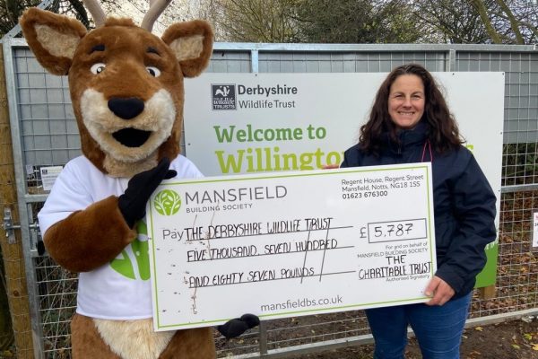 Woman and deer mascot holding cheque derbyshire wildlife trust