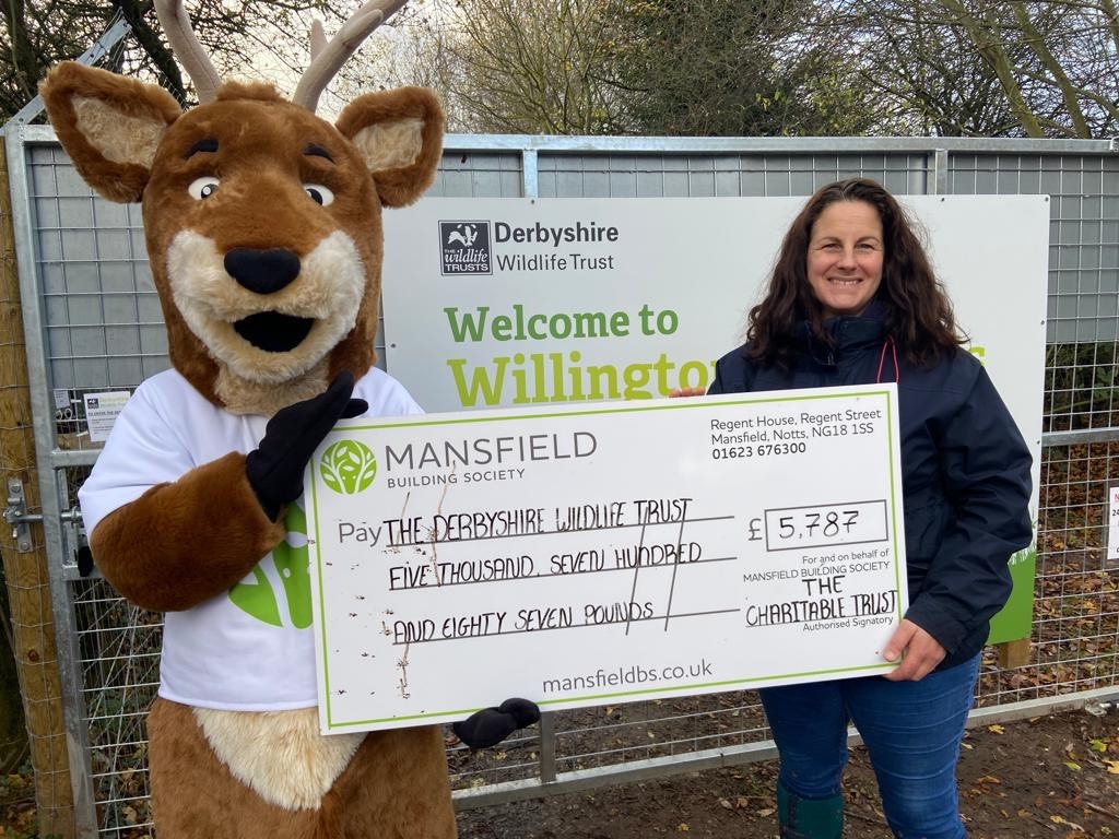 Woman and deer mascot holding cheque derbyshire wildlife trust