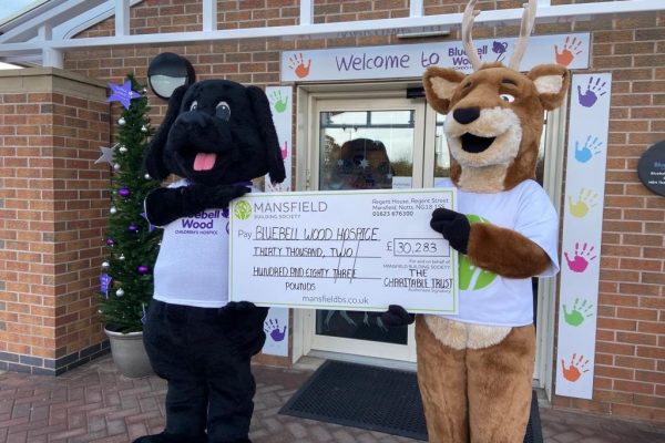 Dog and deer mascot holding cheque - mansfield bs bluebell wood hospice