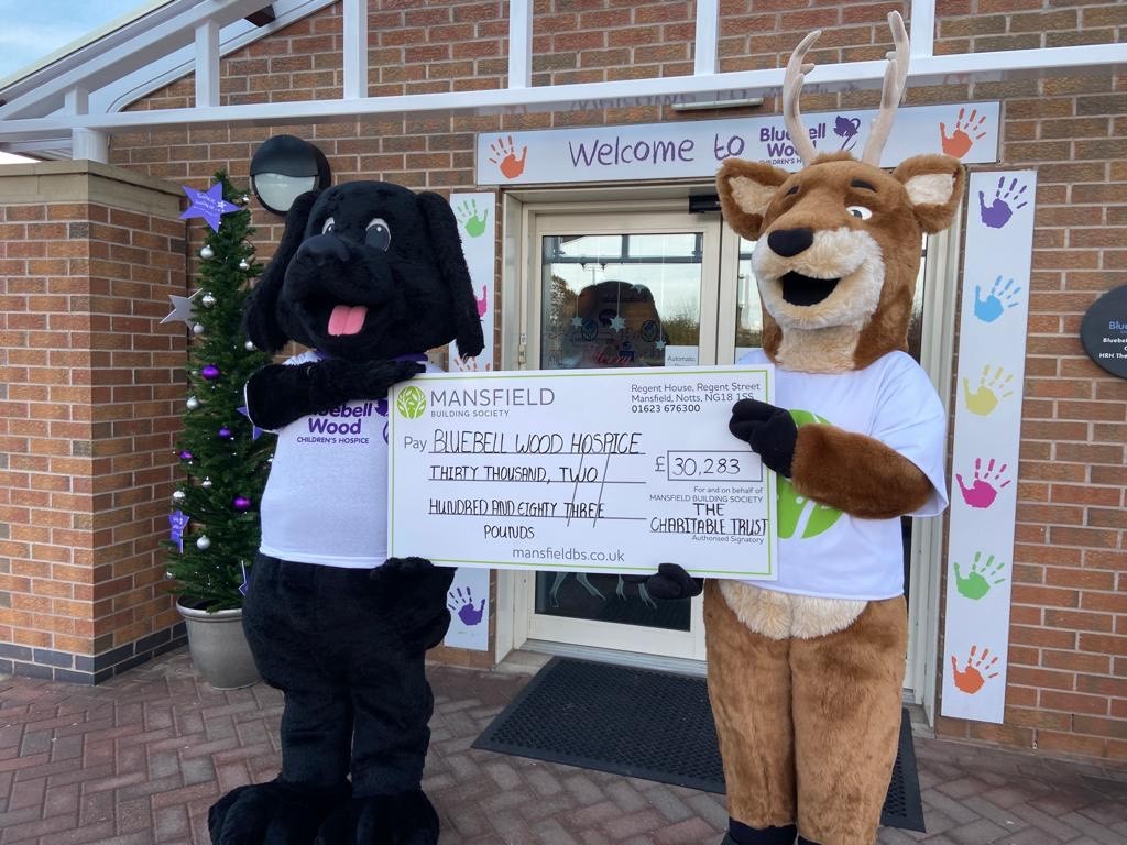 Dog and deer mascot holding cheque - mansfield bs bluebell wood hospice